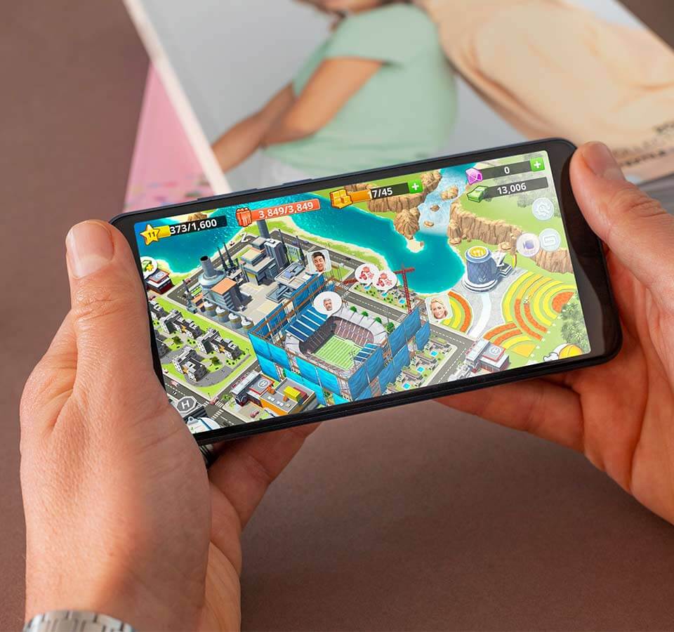 Hai tay cầm chiếc smartphone JERRY4 và chơi game